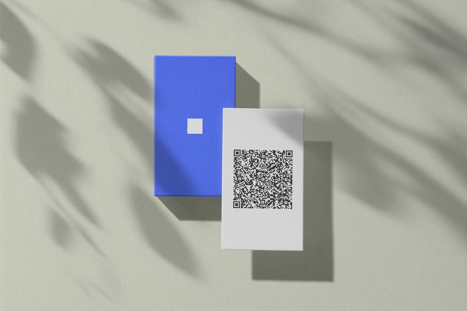 Zwei Visitenkarten auf einem Tisch, eine davon mit aufgedrucktem QR-Code