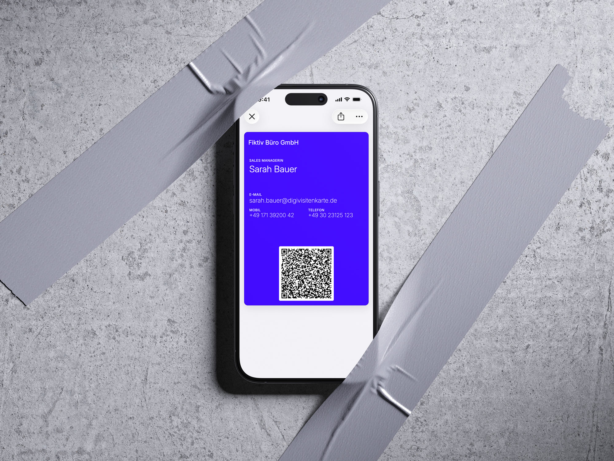 Apple-Wallet-Visitenkarte von Sarah Bauer auf einem iPhone, blau-violette Karte mit scannbarem QR-Code, mit Klebeband an einer Betonwand befestigt
